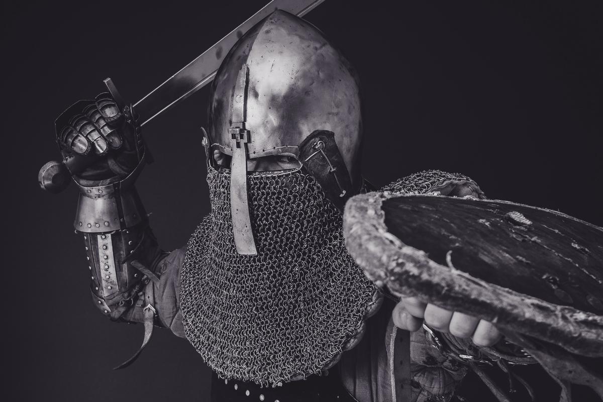 Image of a person holding a shield protecting a computer from cyber risks